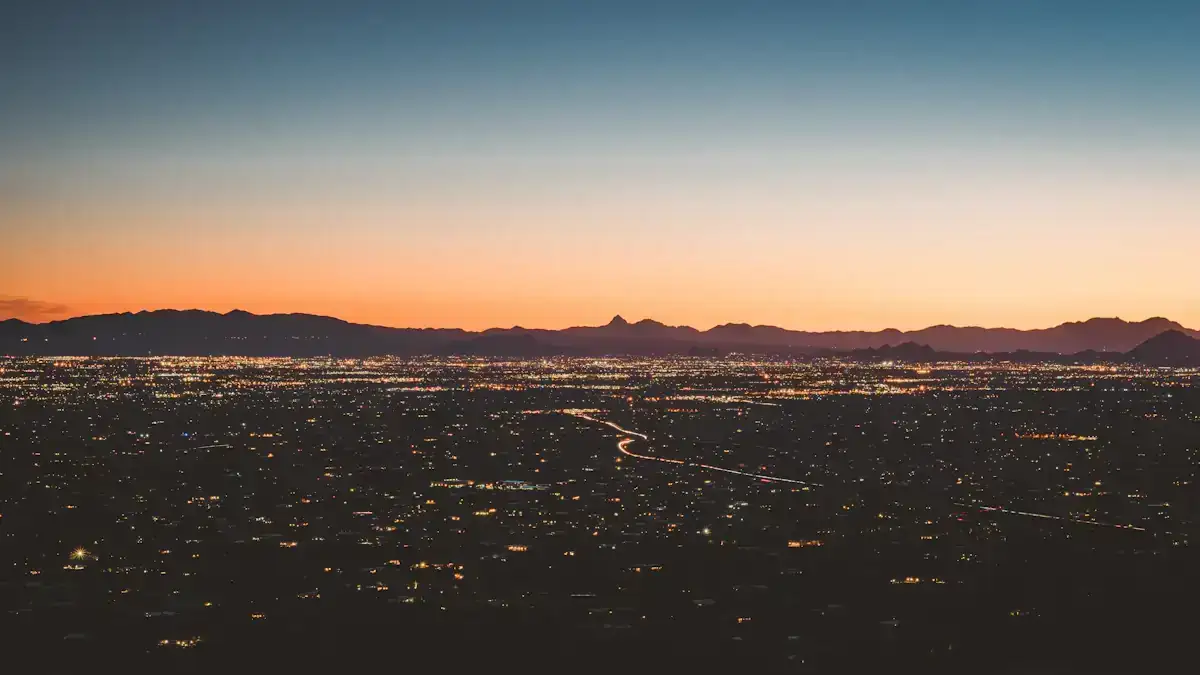 The lights of the Tucson valley at dusk under an orange sky